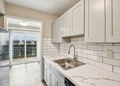 Thumbnail 15 of 27 - A kitchen with a sink and cabinets.