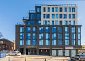 Thumbnail 81 of 81 - A modern building with a glass facade and a sign that reads "Cricket Park".