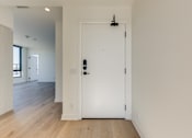 Thumbnail 80 of 81 - A white door with a black handle and lock in a room with wooden floors.