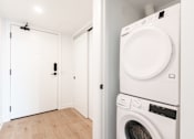 Thumbnail 29 of 81 - A white washing machine and dryer in a laundry room.