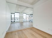 Thumbnail 14 of 81 - A room with a wooden floor and a large mirror on the wall.