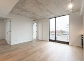 Thumbnail 27 of 81 - A large empty room with wooden floors and white walls.
