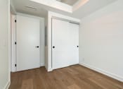 Thumbnail 12 of 81 - A room with two white doors and wooden floors.