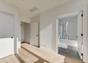 Thumbnail 75 of 81 - A white room with a wooden floor and a large mirror on the wall.
