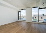 Thumbnail 11 of 81 - Empty room with wooden floor and sliding glass doors.
