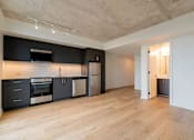 Thumbnail 24 of 81 - A kitchen with black cabinets and stainless steel appliances.