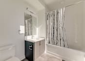 Thumbnail 73 of 81 - A white bathroom with a black cabinet and a white toilet.