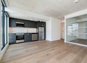 Thumbnail 9 of 81 - A modern kitchen with wooden floors and a glass wall.