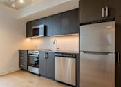 Thumbnail 23 of 81 - A modern kitchen with stainless steel appliances and dark brown cabinets.