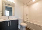 Thumbnail 22 of 81 - A white bathroom with a black cabinet and a white toilet.