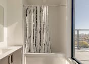 Thumbnail 71 of 81 - A white bathroom with a shower curtain with black branches on it.