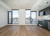 Thumbnail 7 of 81 - A kitchen with a wooden floor and a large window.
