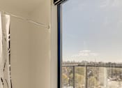 Thumbnail 70 of 81 - A bathroom with a shower curtain and a view of the city.