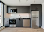 Thumbnail 6 of 81 - A modern kitchen with a stainless steel refrigerator and oven.