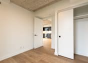 Thumbnail 20 of 81 - A white door is open to a hallway with wood floors.