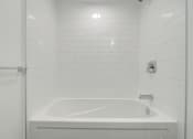 Thumbnail 4 of 81 - A white bathroom with a white tub and a white shower curtain.