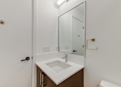 Thumbnail 60 of 81 - A white sink in a bathroom with a mirror above it.
