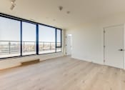 Thumbnail 59 of 81 - A large empty room with wooden floors and a view of the city through the windows.