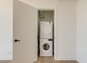 Thumbnail 49 of 81 - A white washing machine is in a small laundry room.