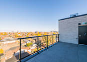 Thumbnail 46 of 81 - A balcony with a black door and a view of a residential area.