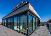 Thumbnail 41 of 81 - A modern building with a glass facade and a flat roof.