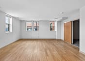 Thumbnail 19 of 20 - A room with wooden flooring and white walls.