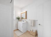 Thumbnail 33 of 36 - A white bathroom with a sink, mirror, and towel.