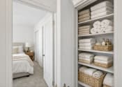 Thumbnail 21 of 36 - A white bathroom with a towel shelf and a bed.