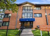 Thumbnail 48 of 58 - The image shows a brick building with a sign that reads "PARK EMBASSY LEASING OFFICE" and a phone number.