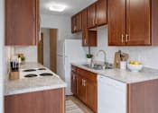 Thumbnail 15 of 58 - A kitchen with brown cabinets and a white fridge.