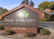 Thumbnail 3 of 58 - A sign for Park Embassy Apartments with a phone number on it.