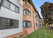 Thumbnail 8 of 58 - A building with a white and brick facade has windows on the side.