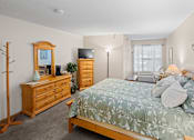 Thumbnail 8 of 59 - A bedroom with a bed, dresser, and mirror.