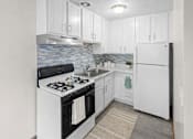 Thumbnail 28 of 39 - A kitchen with white cabinets and a black stove top oven.
