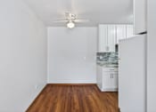Thumbnail 4 of 39 - A room with a ceiling fan and wooden floors.