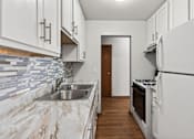 Thumbnail 7 of 39 - A kitchen with white cabinets and a marble countertop.