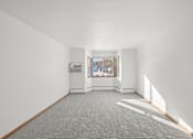 Thumbnail 34 of 39 - A spacious room with a window and a carpeted floor.
