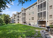 Thumbnail 7 of 59 - A large apartment complex with a grassy area in front.