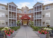 Thumbnail 17 of 59 - an exterior view of an apartment building with a walkway and flowers