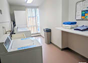 Thumbnail 40 of 58 - A medical room with a machine on the left and towels on the right.