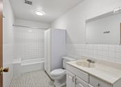 Thumbnail 51 of 58 - A white bathroom with a toilet, sink, and bathtub.