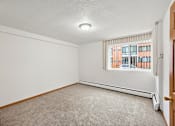 Thumbnail 45 of 58 - A room with a window and a carpeted floor.