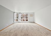Thumbnail 31 of 58 - A room with a carpeted floor and a window with a view of trees.