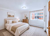 Thumbnail 46 of 58 - A bedroom with a large bed and a window with blinds.