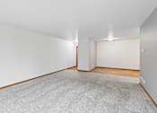 Thumbnail 32 of 58 - A room with a grey carpet and wooden floor.