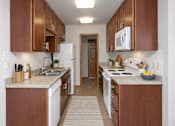 Thumbnail 28 of 58 - A kitchen with brown cabinets and white appliances.