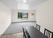 Thumbnail 6 of 36 - A dining room with a table and chairs.