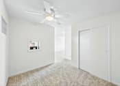Thumbnail 11 of 36 - A room with a ceiling fan and a window with a picture frame on the wall.