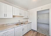 Thumbnail 17 of 36 - A kitchen with white cabinets and a marble countertop.