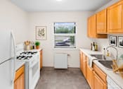 Thumbnail 26 of 36 - A kitchen with white appliances and wooden cabinets.
